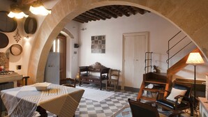 A rustic kitchen with a checkered floor, wooden furniture, and a stone archway. - Holiday Home in Buseto Near San Vito Lo Capo (Buseto Palizzolo)