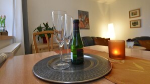 Una mesa de comedor con dos copas de vino, una botella y una vela.