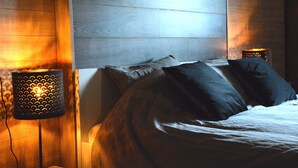 Un dormitorio con una cama, dos lámparas de noche y un cuadro en la pared.