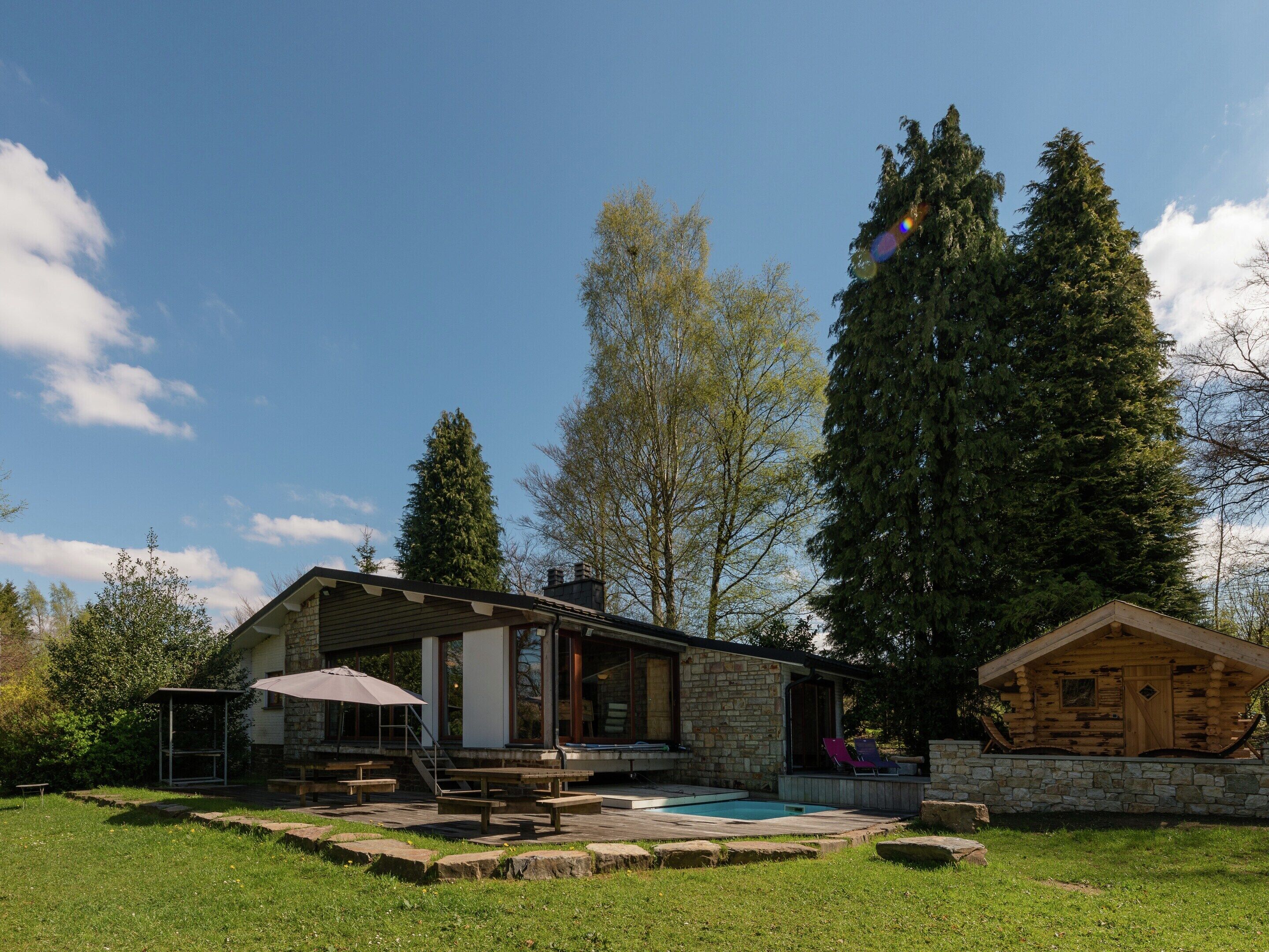 A stone building with a pool and outdoor seating.