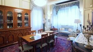 A traditional dining room with a wooden dining table, chairs, and a cabinet with glass doors. - Elegant Art Nouveau Villa With Private Pool Near the Lake (Desenzano del Garda)