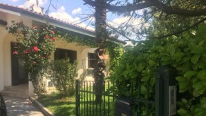 A residential property with a paved driveway, a green metal gate, and a house with a tiled roof. - Villa in Northern Italy Near Borgo di Toppo (Travesio)