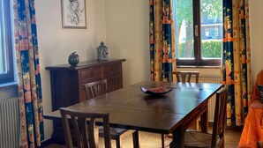 A dining area with a wooden table, chairs, a decorative lantern, and a framed picture on the wall. - Villa in Northern Italy Near Borgo di Toppo (Travesio)