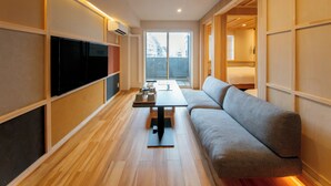 Un salon moderne avec un canapé, un téléviseur à écran plat et une table à manger.