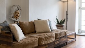 A modern living room with a sectional sofa, a floor lamp, and a potted plant.