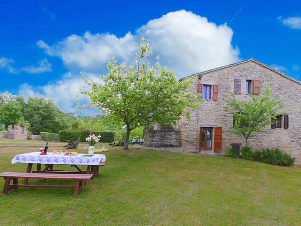 Enjoy outdoor dining or relaxation in a serene natural setting with a picnic table on the well-maintained lawn.