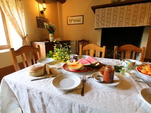 Enjoy a warm meal in this inviting dining room with a table set for a meal, surrounded by comfortable chairs and a fireplace.