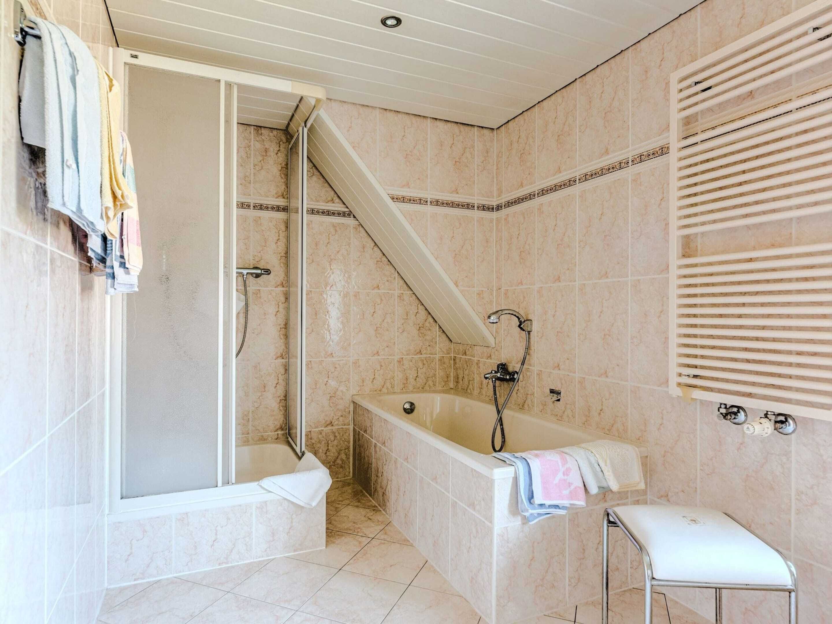A bathroom with a glass-enclosed shower, a freestanding bathtub, and a vanity with a towel rack.