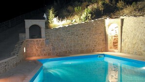 A swimming pool with stone walls and a small arched entrance. - Villa in Crete With Private Pool & Views (Heraklion)