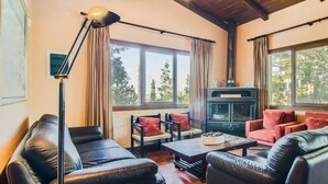 A cozy living room with leather sofas, a coffee table, and a fireplace. - Villa in Crete With Private Pool & Views (Heraklion)