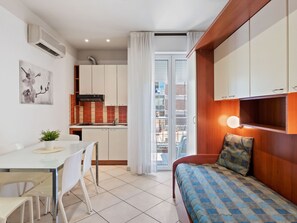 A compact living space with a kitchenette, a dining area, and a bedroom. - Belvilla by OYO Riviera Bilo (Rimini)