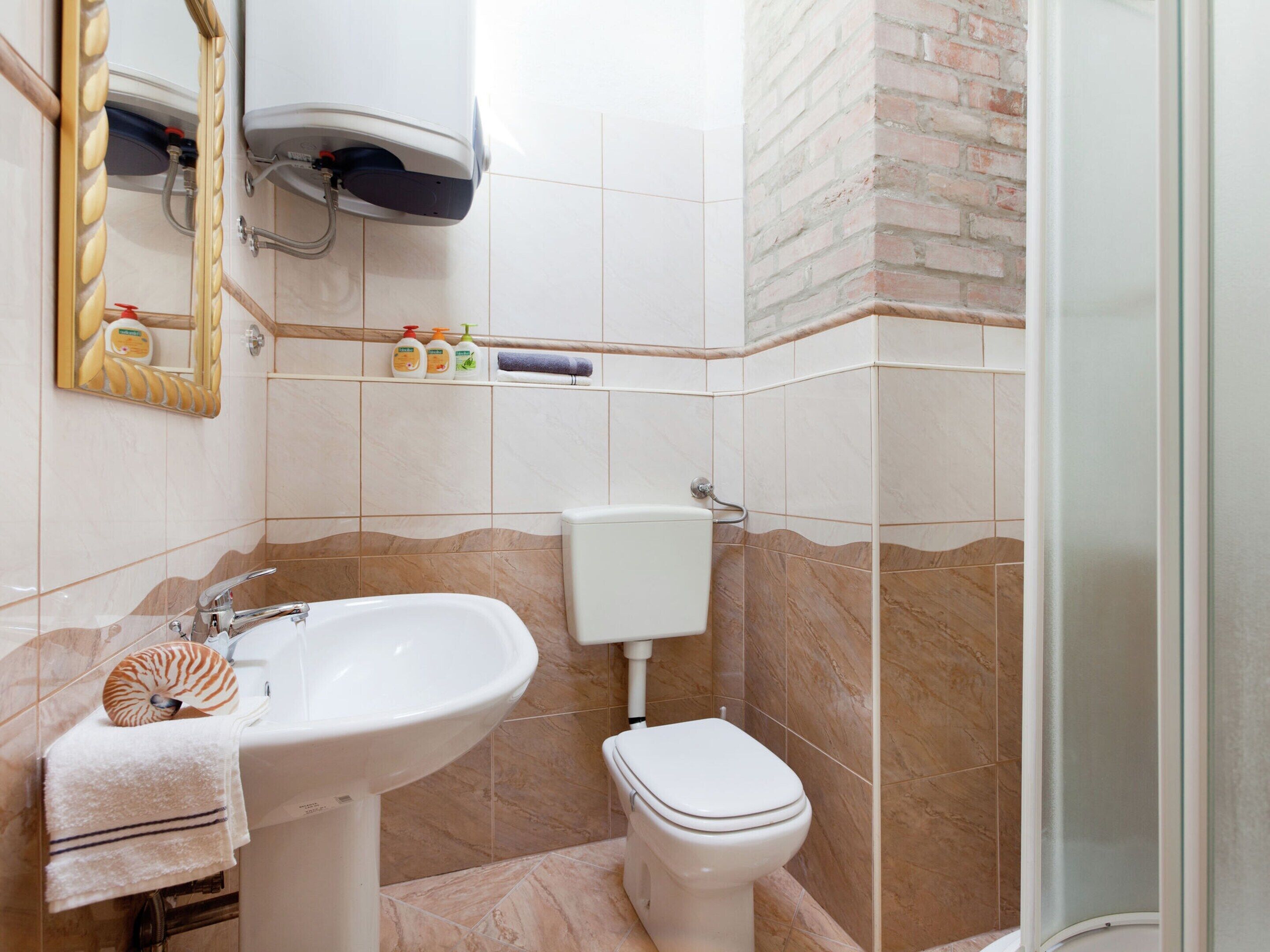 A bathroom with a sink, toilet, and shower.