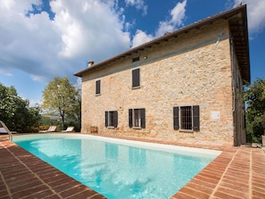 Un bâtiment en pierre avec une piscine.