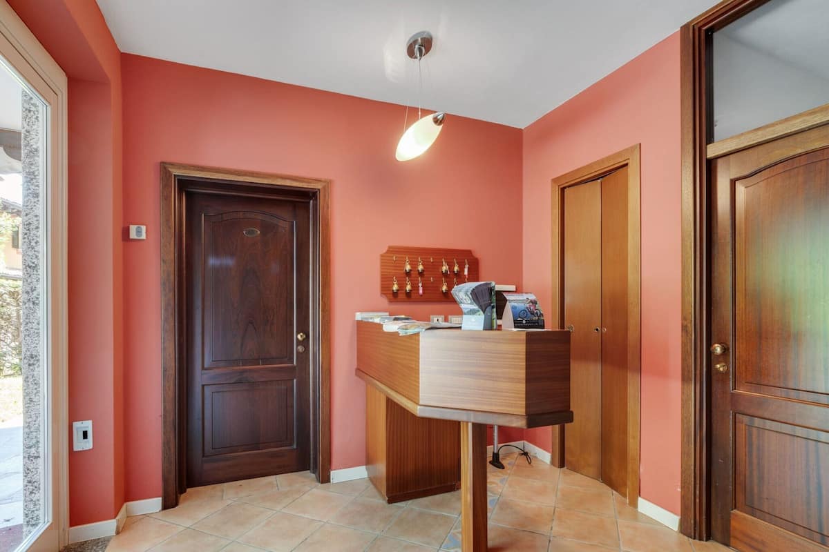 A hallway with a wooden reception desk, a door, and a wall-mounted display.