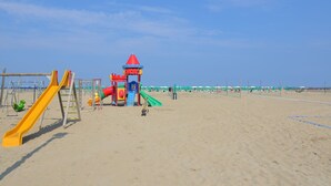 Un parque infantil en la playa con toboganes y estructuras para escalar.