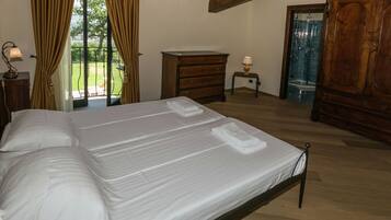Una camera da letto con un letto grande, una cassettiera in legno e vista sull'esterno.