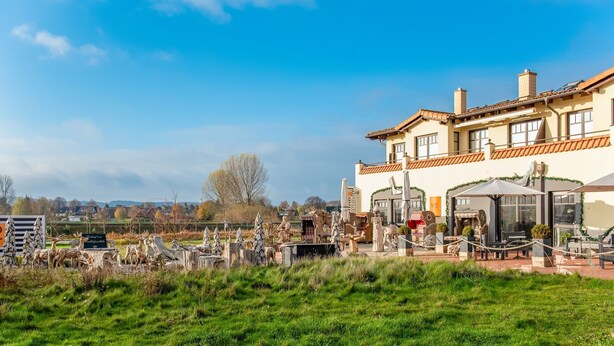 A large house with a patio area featuring outdoor furniture and a variety of animal sculptures. - Idyllic Apartment in Kühlungsborn Germany near Forest (Kuehlungsborn)