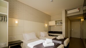 Habitación de hotel con dos camas, un escritorio y un baño.