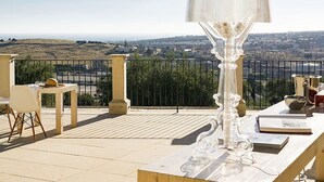 A balcony with a clear view of a cityscape, a table with a lamp, and a chair. - Belvilla by OYO Corte Dorata (Scicli)