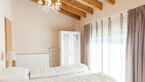 A bedroom with a bed, a wardrobe, a radiator, and a chandelier. - Beautiful Holidayhome With Sauna and Terrace (Harscheid)