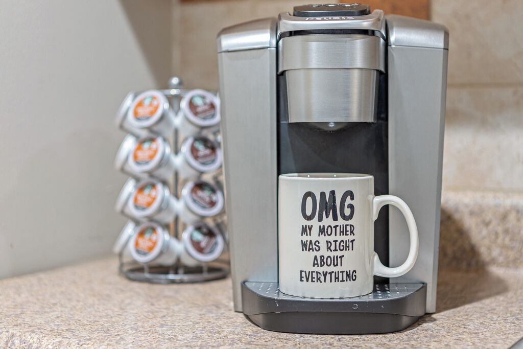 A coffee maker with a mug on its drip tray.