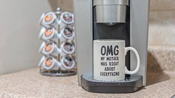 A coffee maker with a mug on its drip tray.