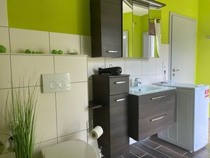 Tina con regadera, secadora de cabello, toallas, papel de baño