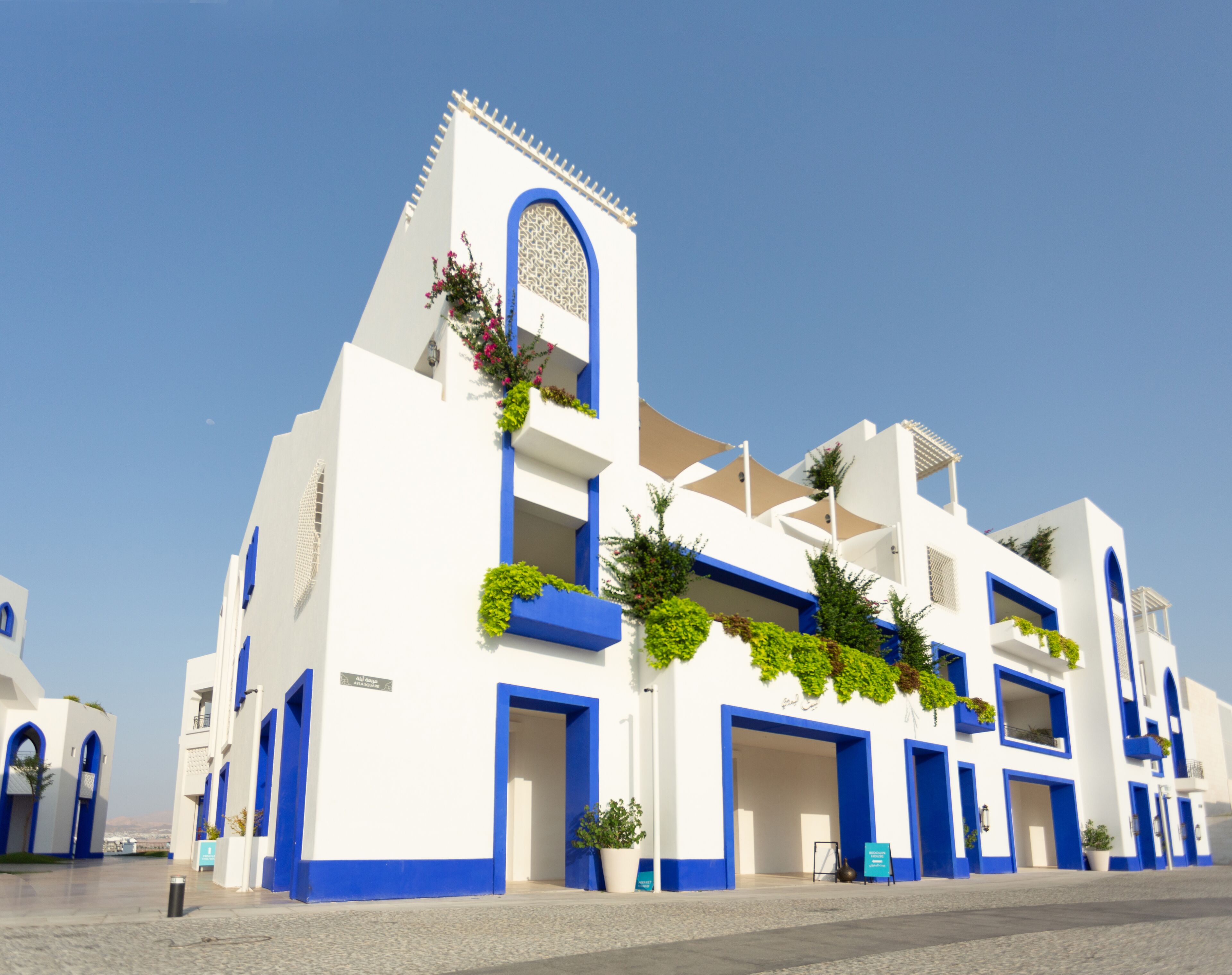 Un edificio blanco con detalles azules y una ventana central arqueada.