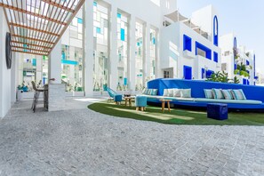 A modern hotel lobby with a central seating area, a staircase, and a view of the interior and exterior. - Cloud 7 Residence Ayla Aqaba (Aqaba)