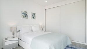A modern bedroom with a bed, nightstands, and artwork on the wall. - In the Funchal city center, Santa Luzia I (Funchal)