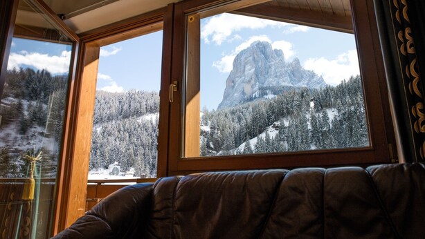 Una habitación con ventanas amplias que ofrecen vistas a un paisaje montañoso nevado.