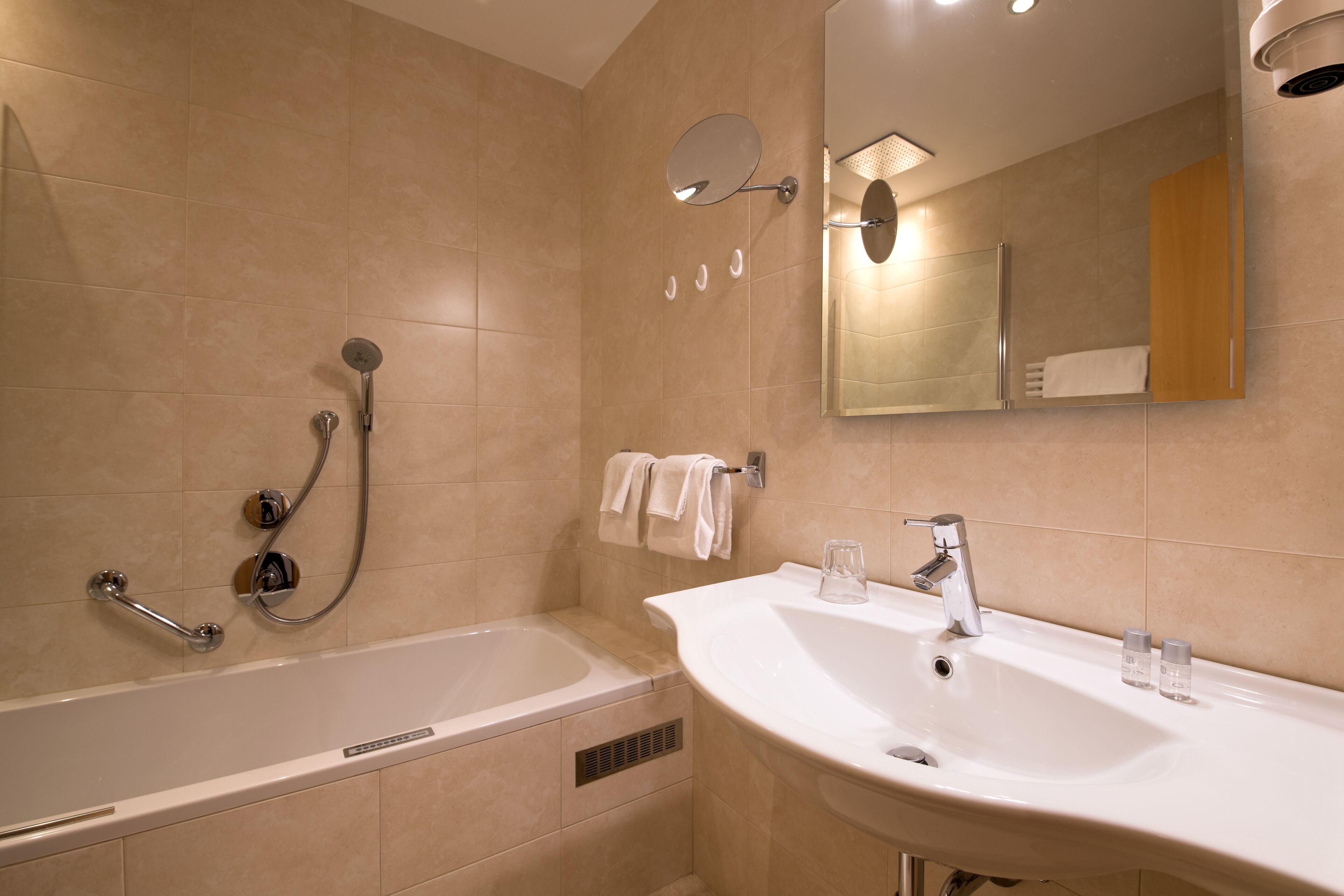 A modern bathroom with a bathtub, a sink, and a mirror.