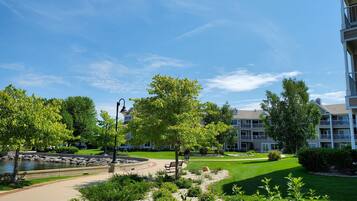 A residential area with a well-maintained lawn, a walking path, and a small pond.