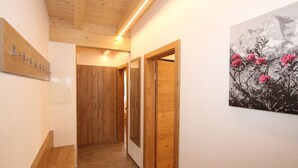 A hallway with wooden flooring, wooden doors, and a wall-mounted light fixture. - Luxury Holiday Flat With Balcony in Fugenberg (Fuegenberg)