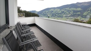 A balcony with a row of chairs and a table, overlooking a mountainous landscape. - Luxury Holiday Flat With Balcony in Fugenberg (Fuegenberg)