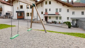 A residential building with a swing set in the foreground.