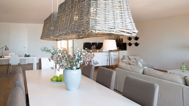 A modern living room with a dining table, sofas, and a hanging light fixture. - Modern Apartment in The Hague (The Hague)