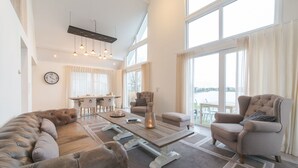 Un salon spacieux comprenant un grand canapé, une table basse et un coin repas avec une table et des chaises.