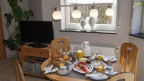 Una escena de desayuno con televisión, alimentos para el desayuno y una ventana decorada con luces.