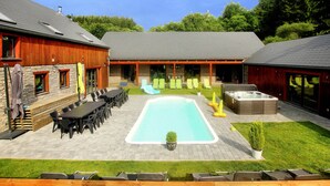 Quintal com piscina, área de estar externa e varanda coberta.