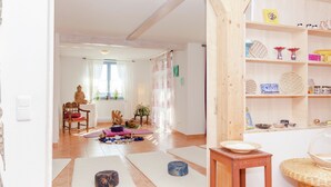 A room with a wooden floor, a small table, a chair, and a shelf with various items. - Villa mit Sauna und Garten (Schotten)