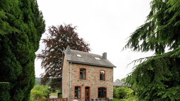 A stone house with a gravel driveway, surrounded by dense greenery. - Rustic Ardennes Retreat (Vielsalm)