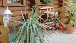 A wooden cabin with a porch, a bench, and potted plants. - Family Getaway in Dankerode (Harzgerode)