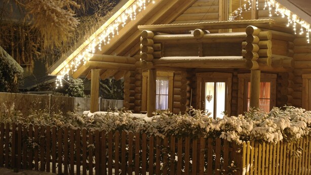 A log cabin with a porch, surrounded by a wooden fence and snow-covered plants. - Family Getaway in Dankerode (Harzgerode)