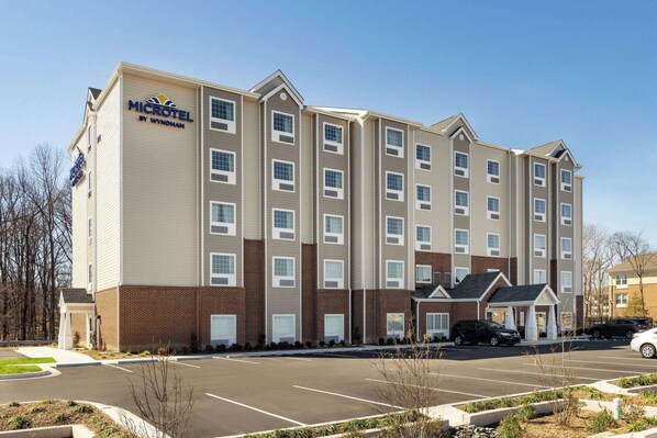 A Microtel by Wyndham hotel with a parking lot and a brick facade. - Microtel Inn & Suites by Wyndham Gambrills (Gambrills)