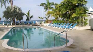 Alberca al aire libre y camastros