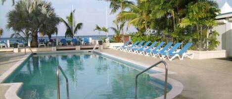 Een buitenzwembad en ligstoelen