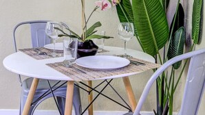 Un comedor con una mesa redonda, sillas, un florero con flores y cuadros en la pared.