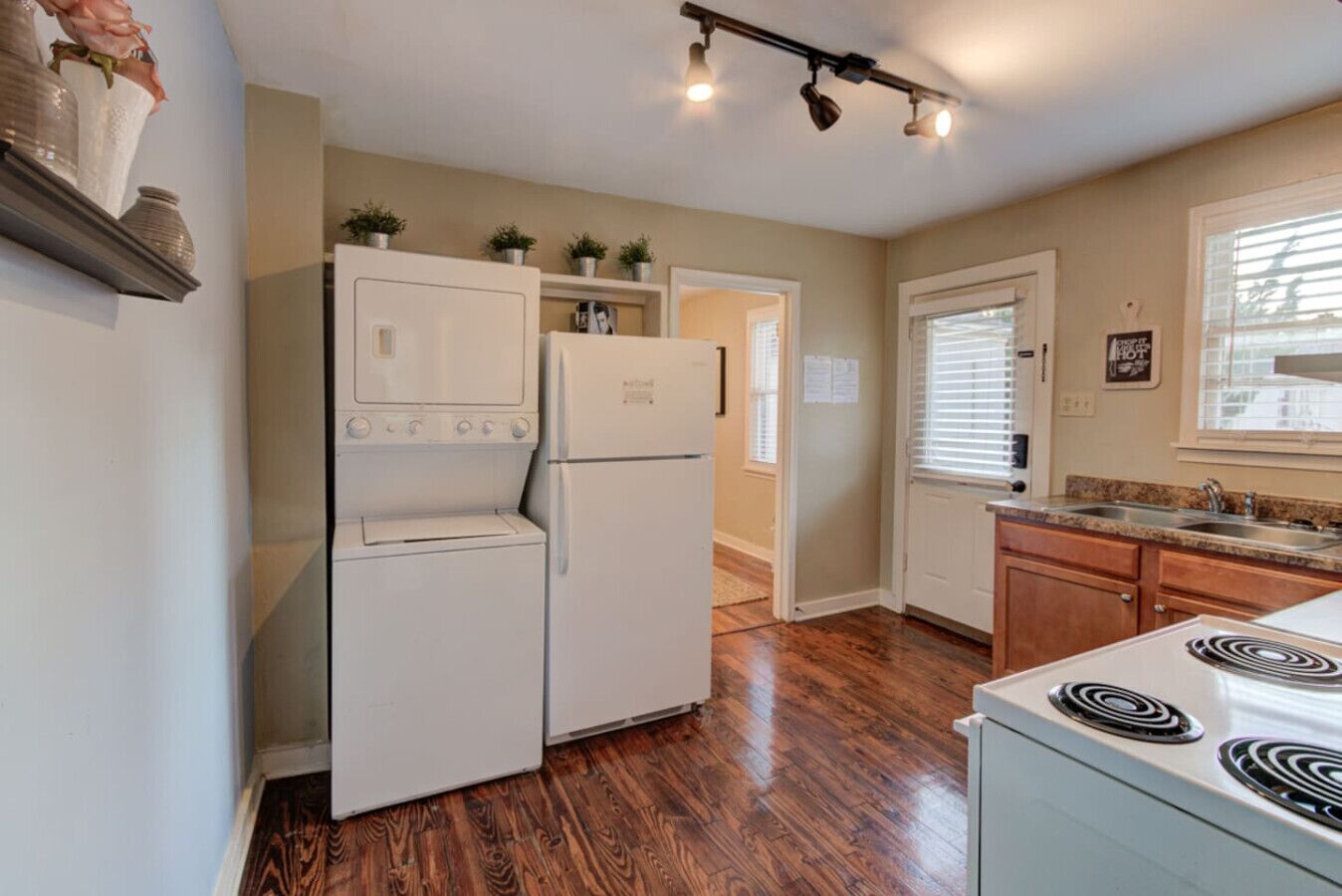 A compact kitchen with a built-in washer-dryer, a stove, and a sink.