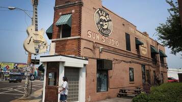 Un edifici de maó amb un rètol que diu “Sun Studio” i una escultura de guitarra a l'exterior.